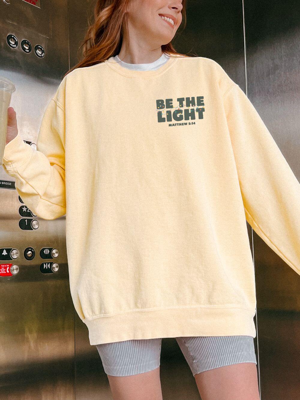 Be The Light Matthew 5:14 Christian Faith Comfort Colors Christmas Crewneck Sweatshirt - Sydney So Sweet