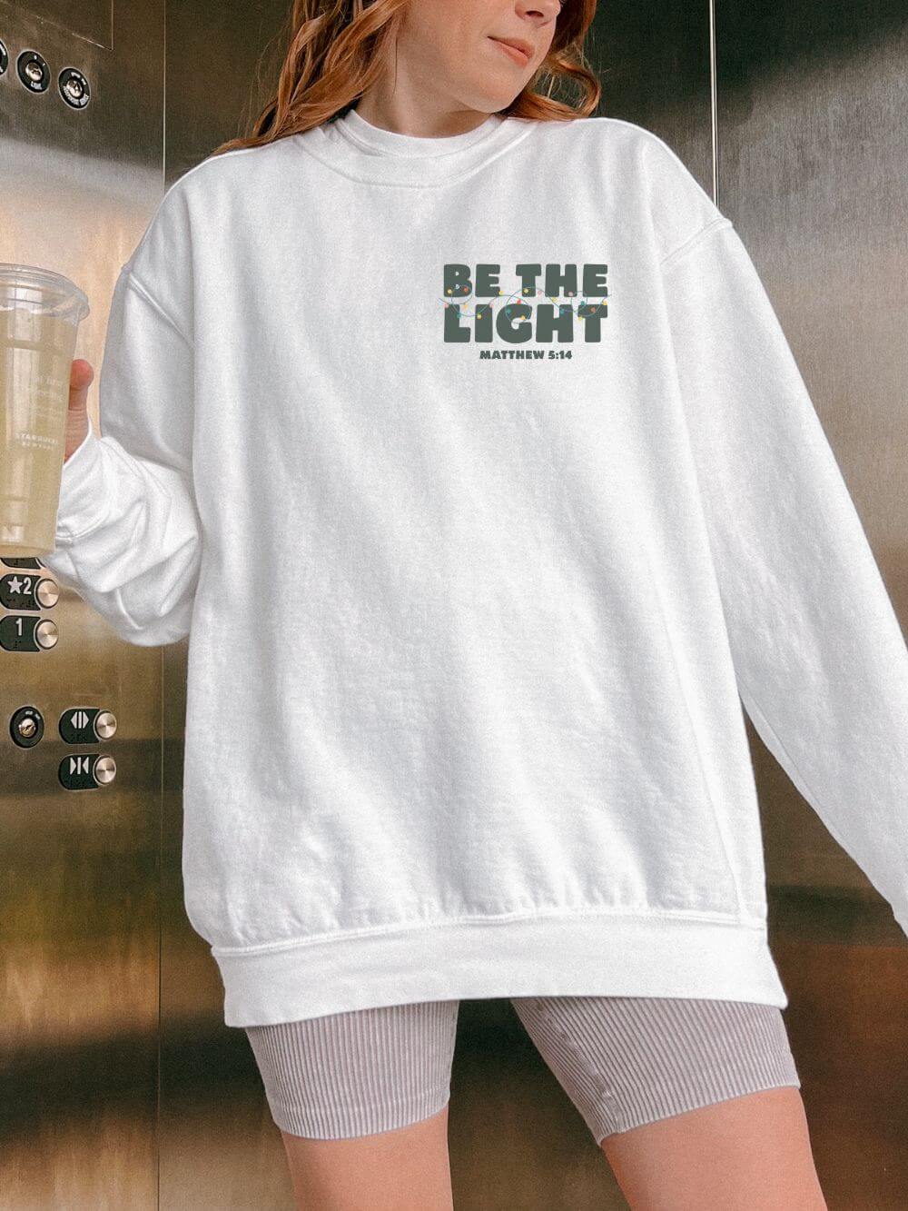 Be The Light Matthew 5:14 Christian Faith Comfort Colors Christmas Crewneck Sweatshirt - Sydney So Sweet