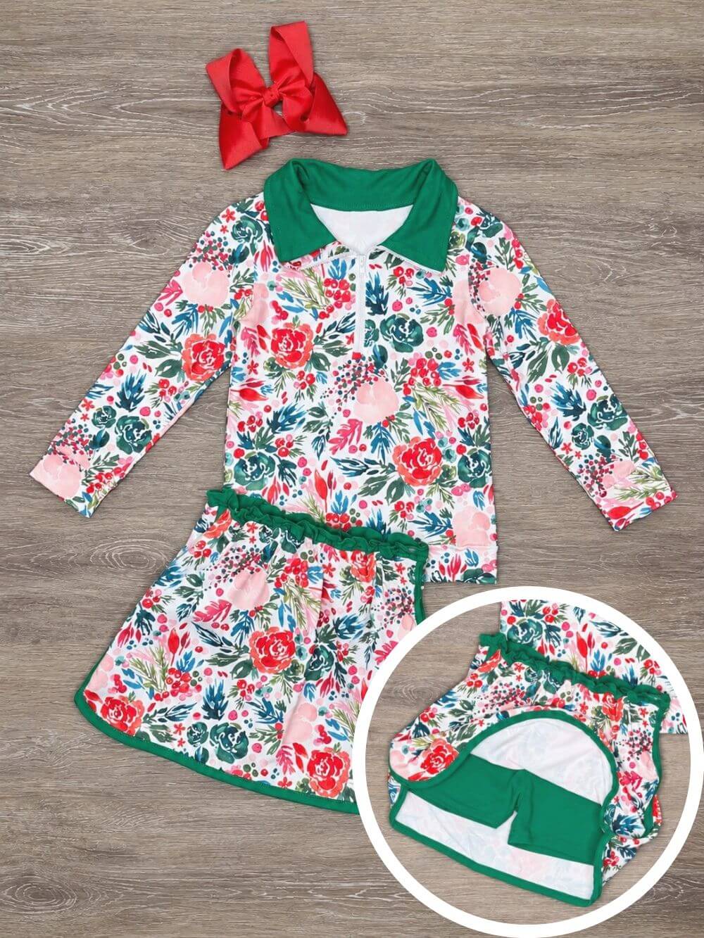 Girls holiday floral quarter zip top and matching skort with green trim laid flat with quarter zip collar detail