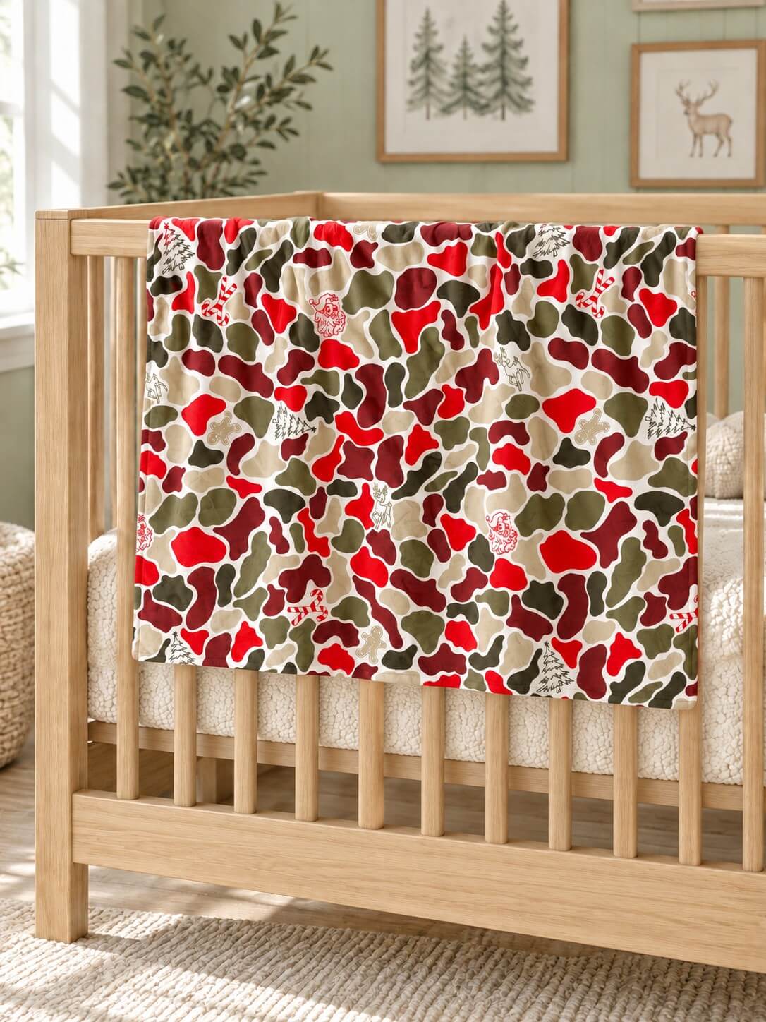 Christmas camouflage baby blanket with red minky dot backing draped over a crib rail