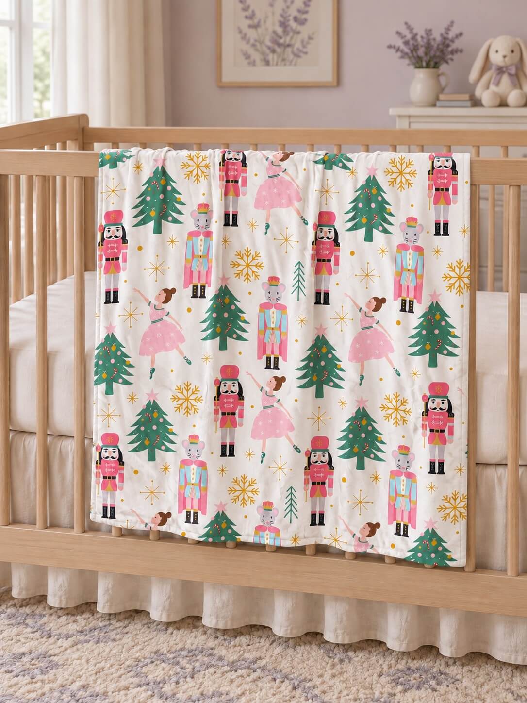 Pink nutcracker and Christmas tree baby blanket with pink minky dot backing draped over a crib rail