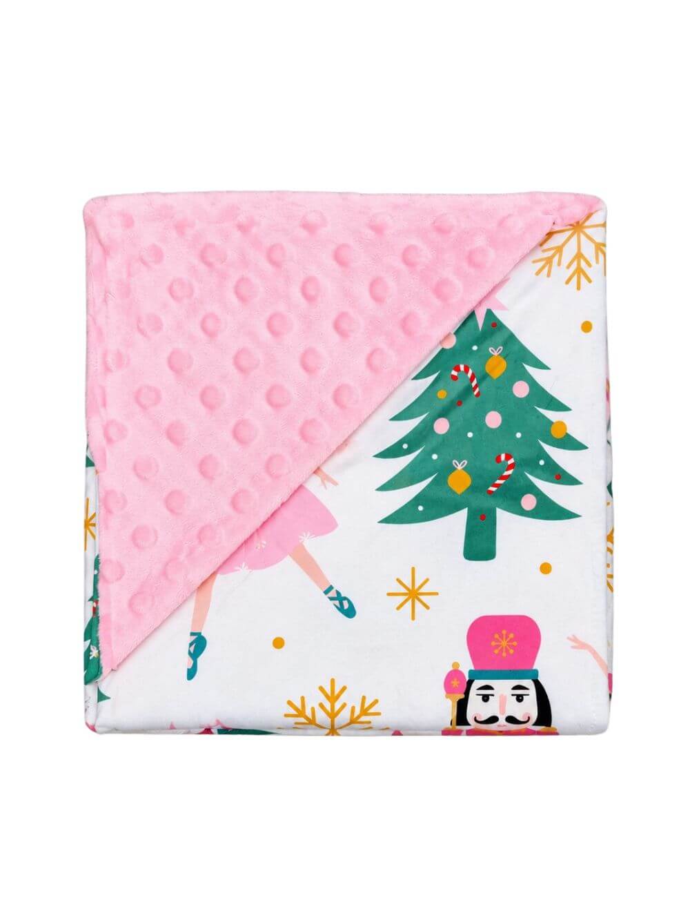 Pink nutcracker and Christmas tree baby blanket with pink minky dot backing folded on white background to show the reverse