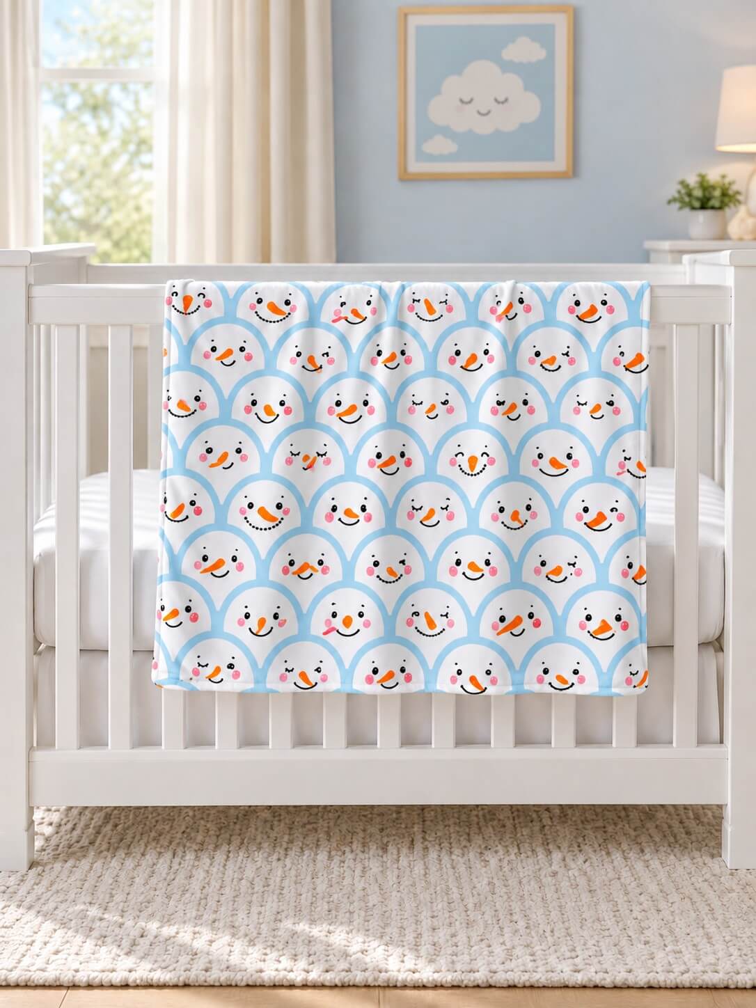 Blue snowman baby blanket with blue minky dot backing draped over a crib rail